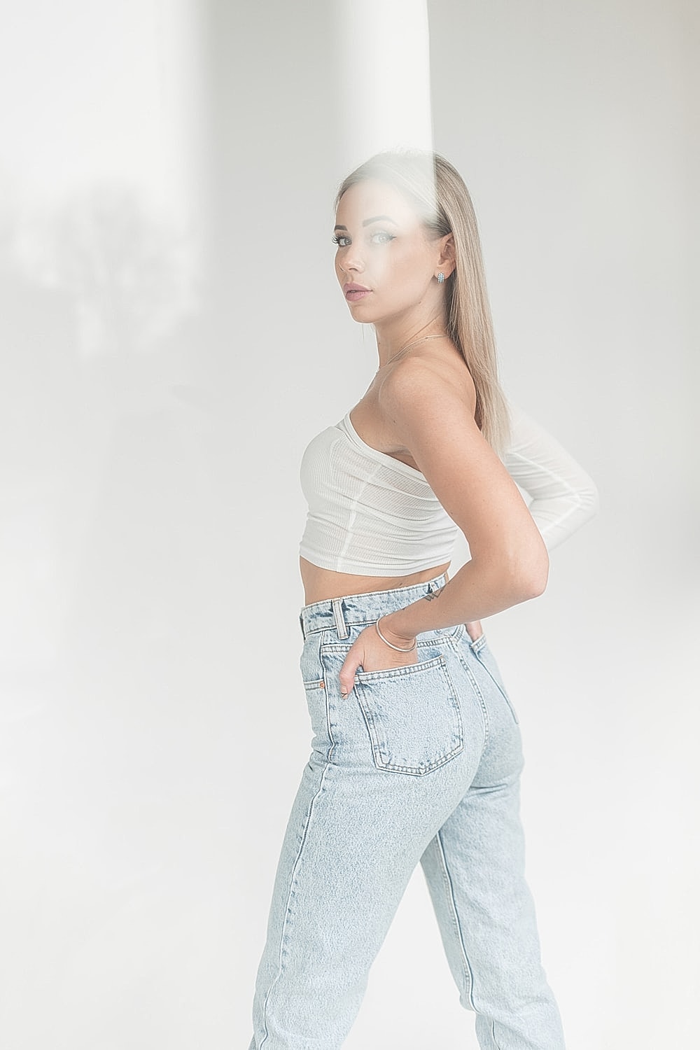 Model in cropped top and high-waisted jeans.