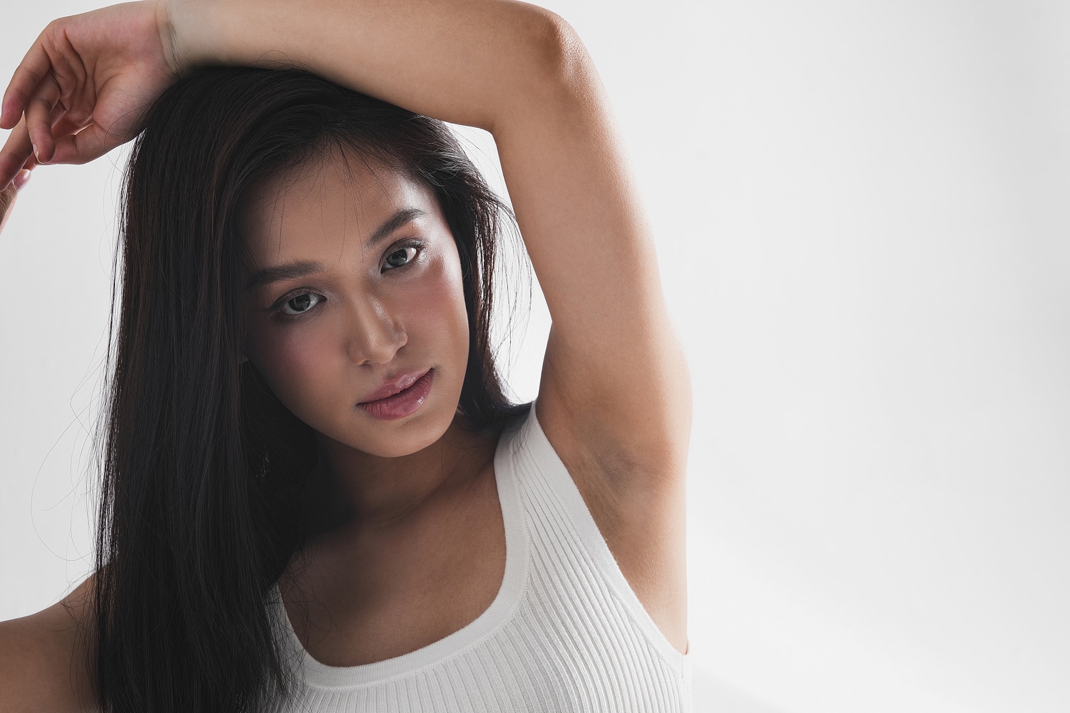 Young woman with long dark hair posing elegantly.